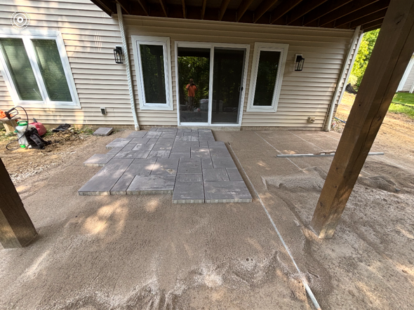 Covered patio with a tiled surface and sliding glass doors beside a house