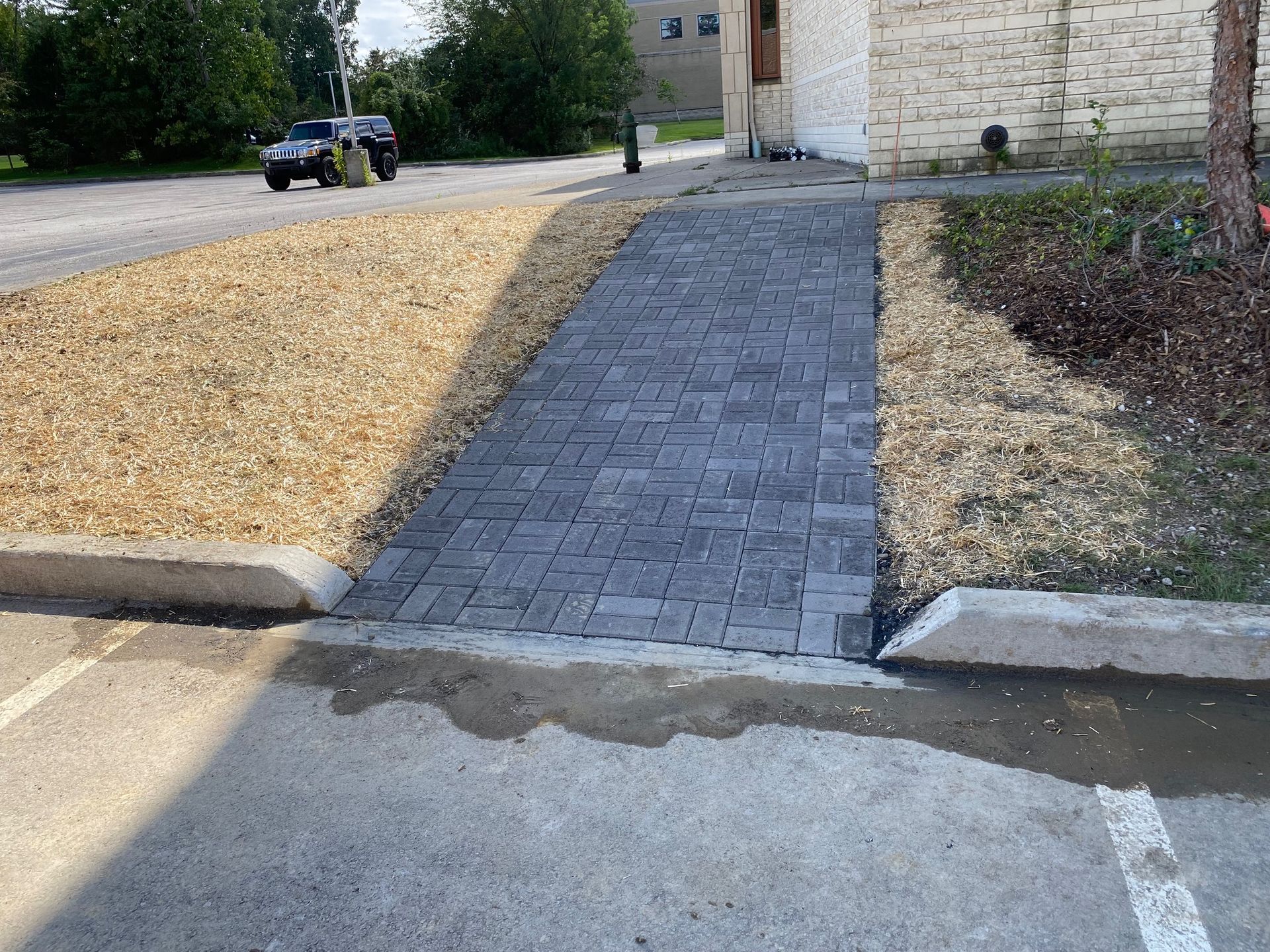 Accessible ramp with paver walkway leading from a road curb to a building entrance