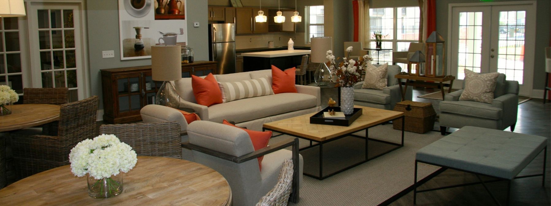 Cozy living room with gray sofa, orange accents, fireplace, and large windows