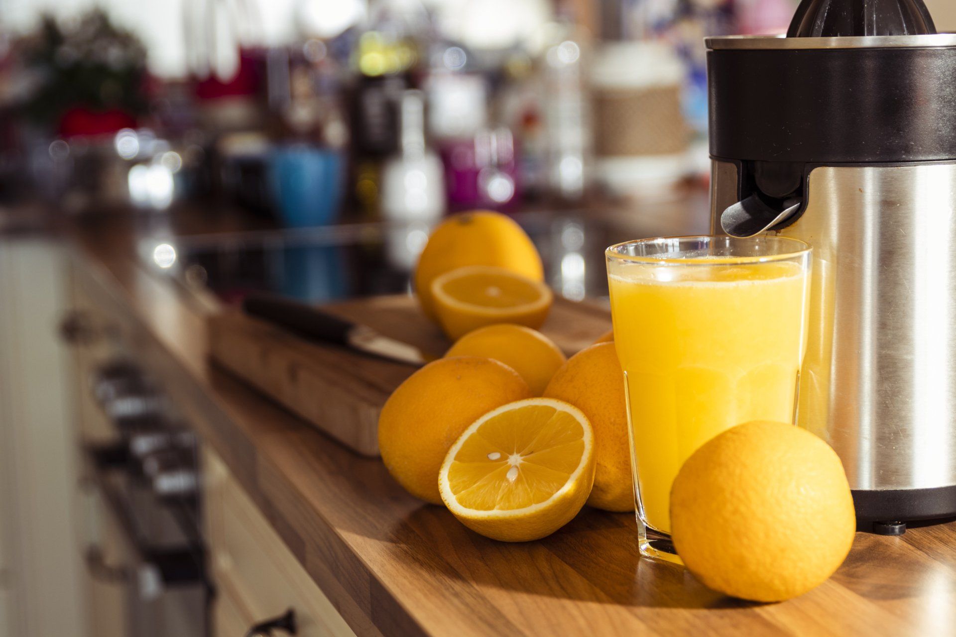 Naranjas y un vaso de jugo de naranja en la encimera de la cocina.