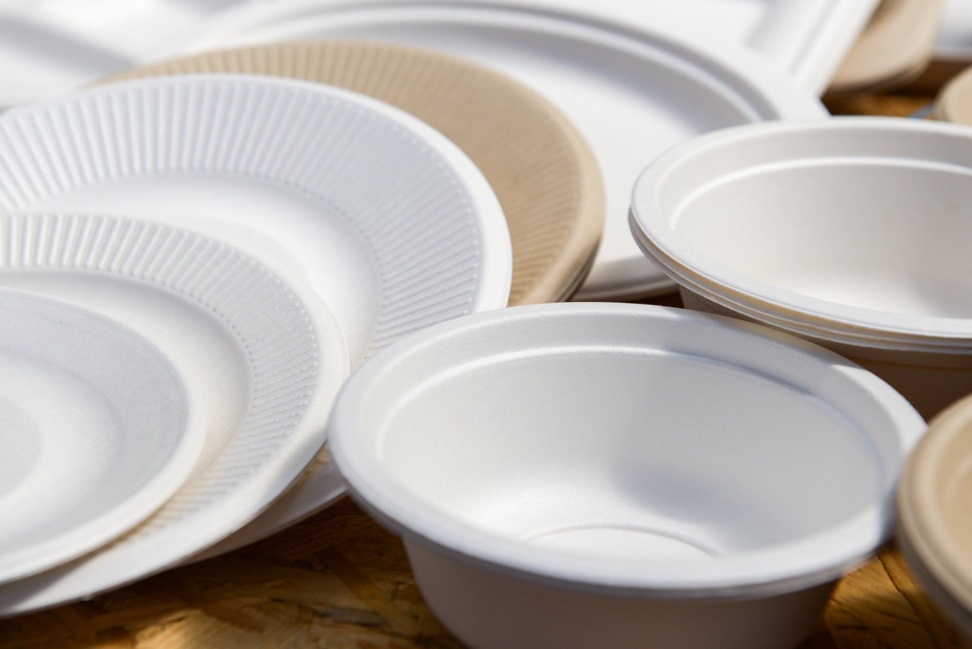 Un montón de platos y tazones de papel sobre una mesa