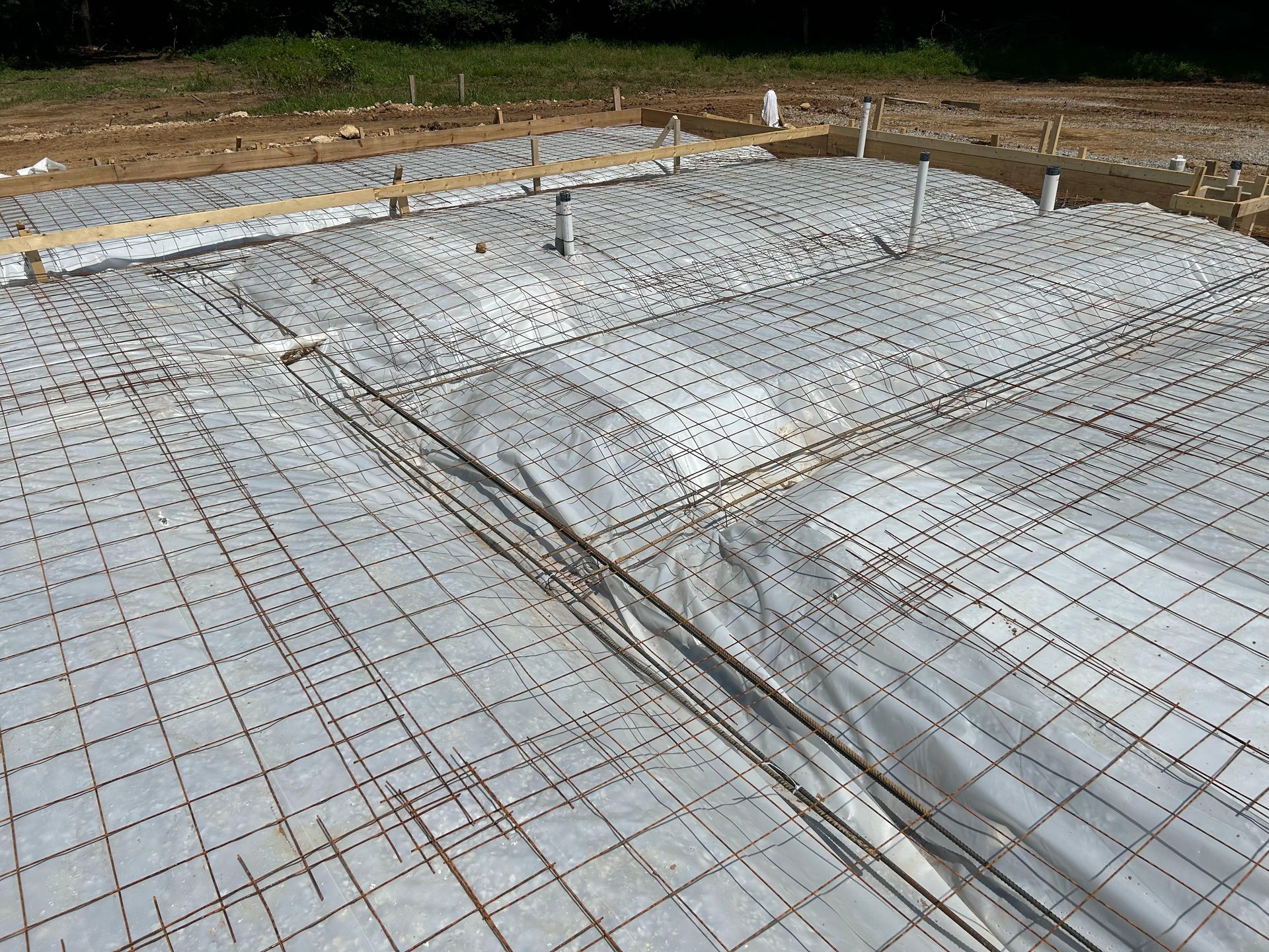 A concrete foundation is being built on a construction site.