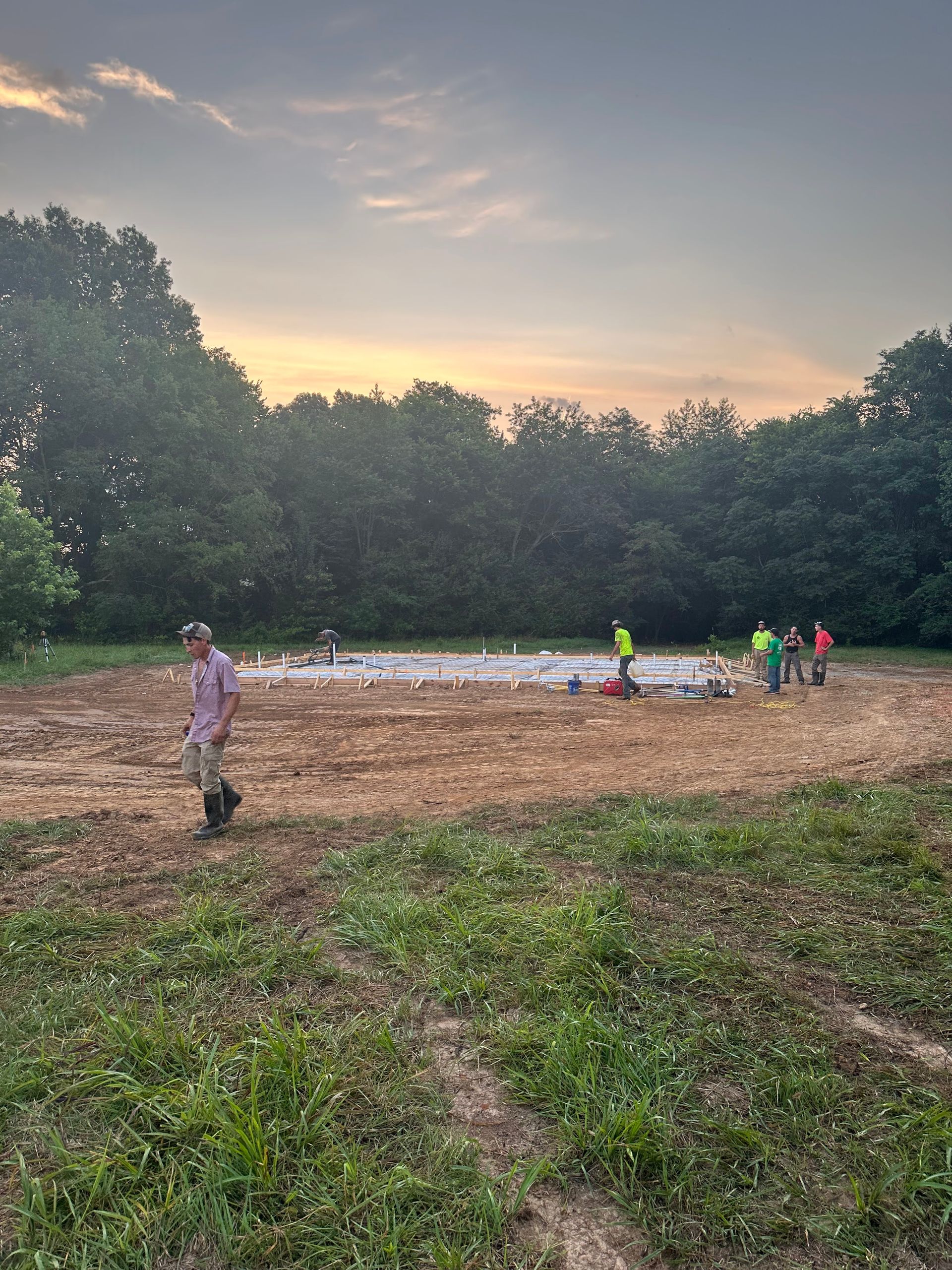 A group of people are working on a construction site in a field.