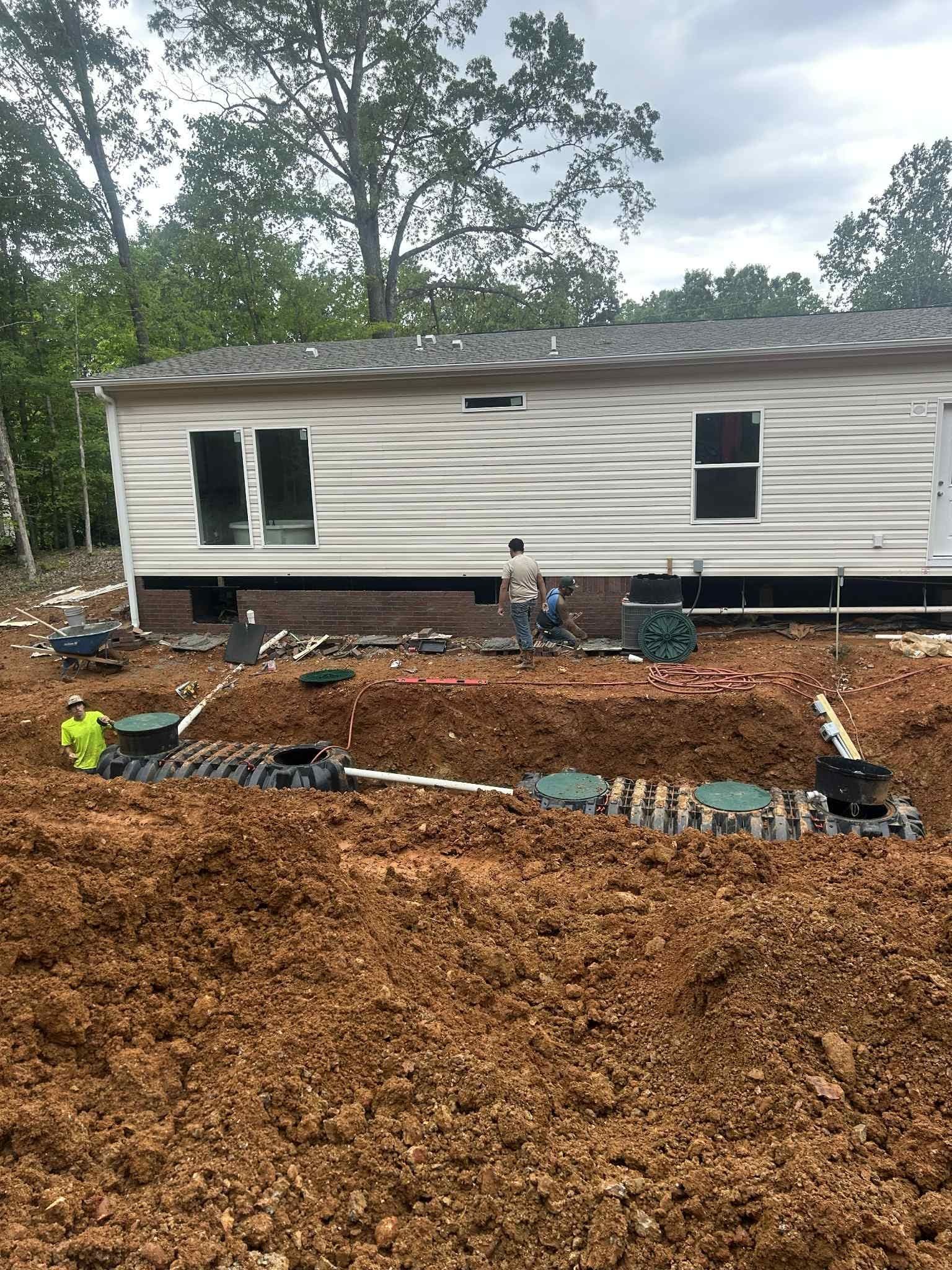 A mobile home is being built in a dirt field.