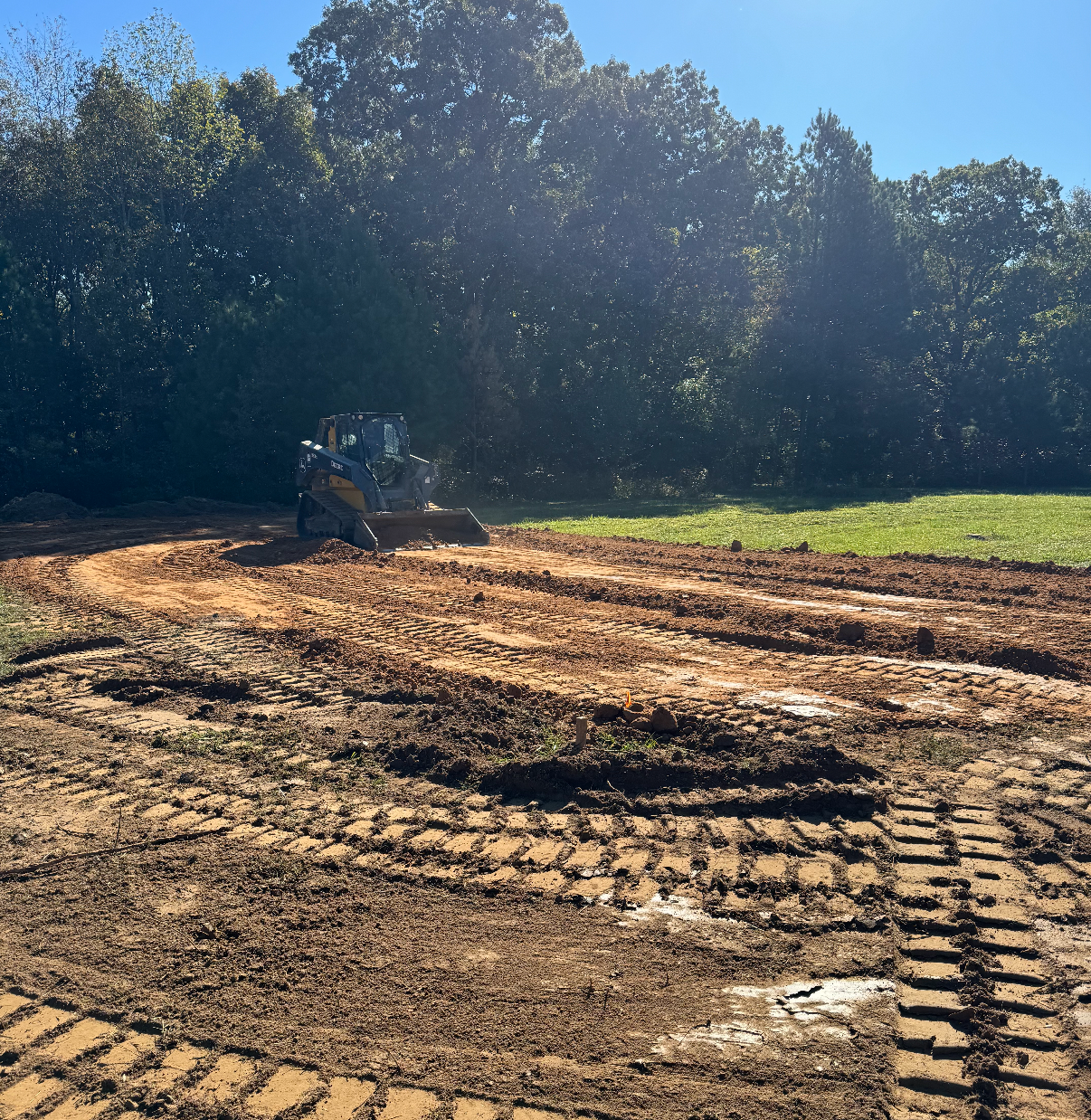 A bulldozer is driving through a muddy field.
