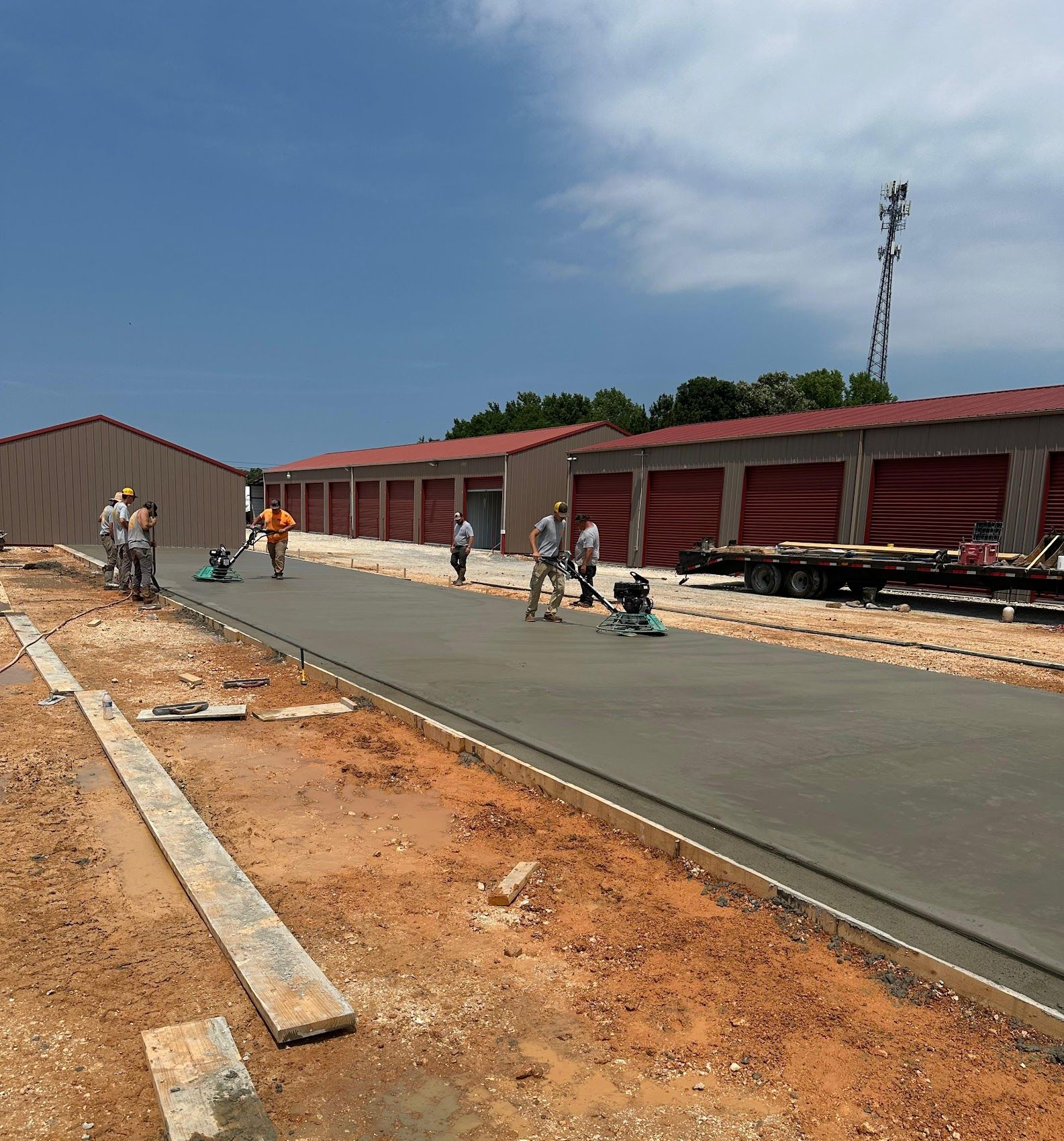 A man is working on a concrete slab in front of a house.