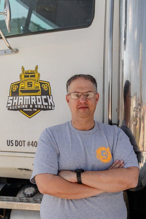 A man standing in front of a shamrock truck