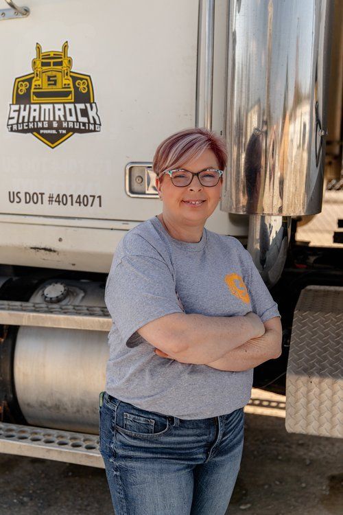 A woman is standing in front of a shamrock truck