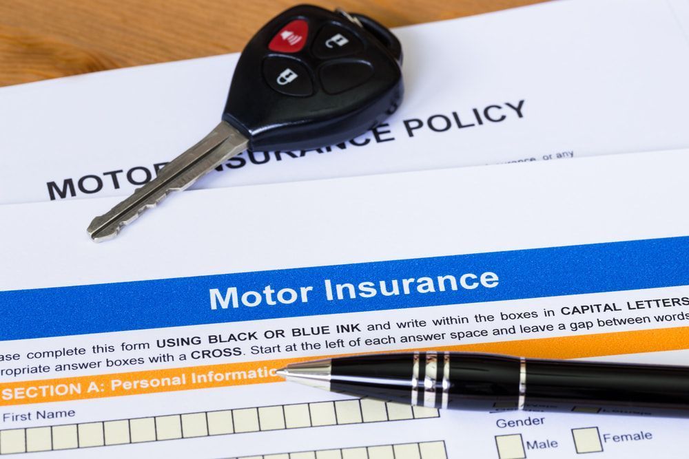 A Car Key Is Sitting On Top Of A Motor Insurance Policy — Windscreen Ambulance In Kawana, QLD