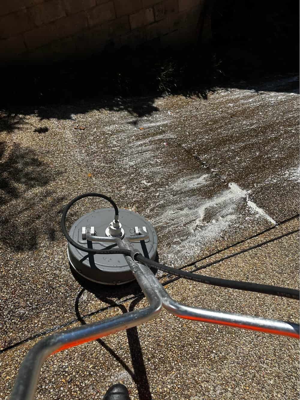 A Person is Using a Machine to Clean a Sidewalk — Lighthouse pressure washing in Port Macquarie, NSW