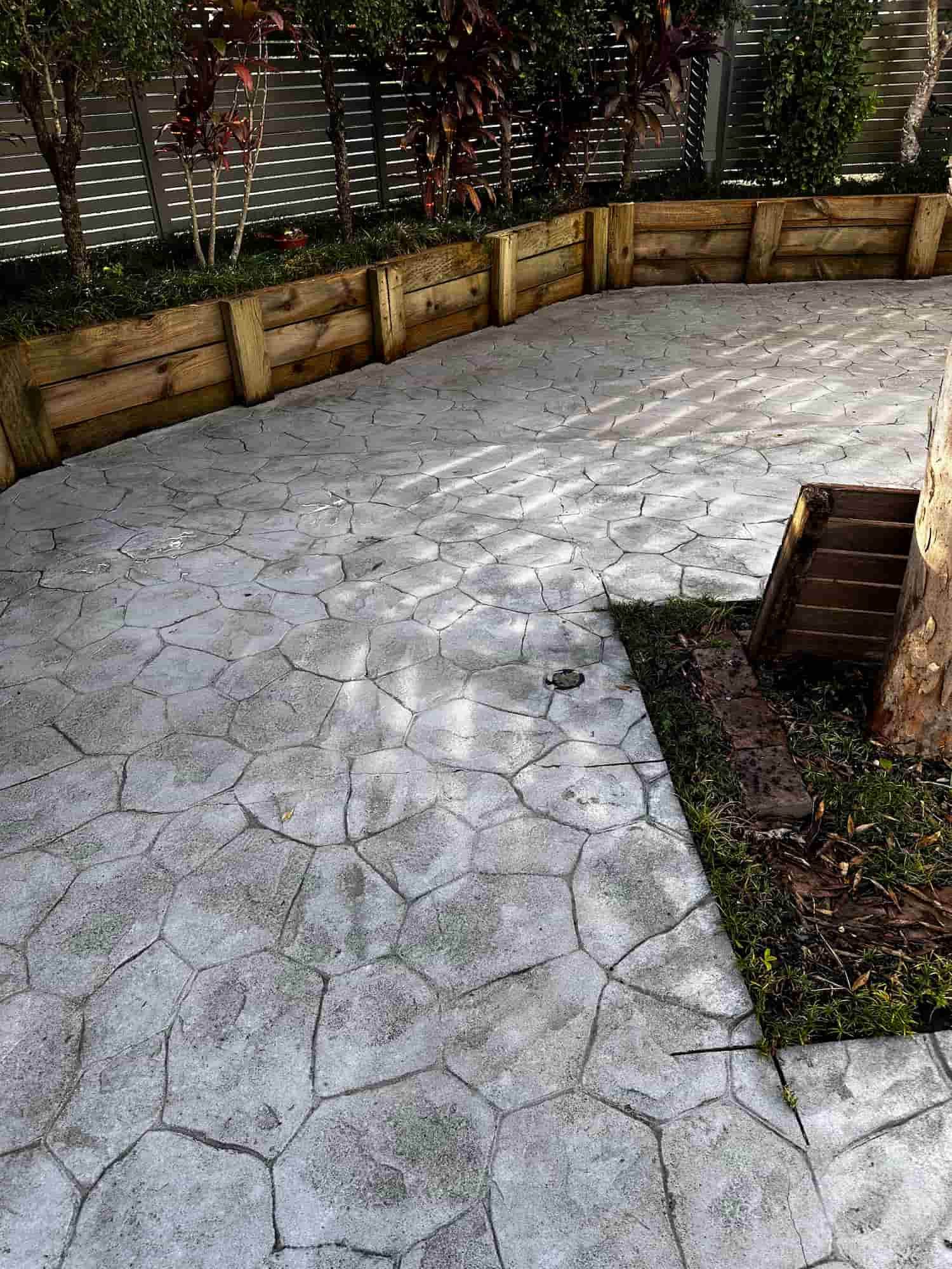 A Concrete Patio With a Wooden Fence Surrounding It — Lighthouse pressure washing in Lake Cathie, NSW