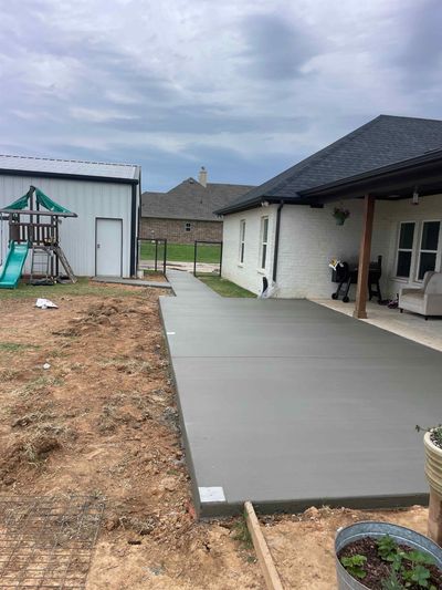 A concrete walkway is being built in front of a house.