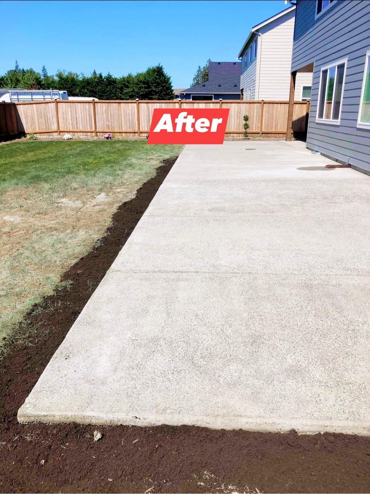 Finished concrete patio next to a house with a grass lawn.