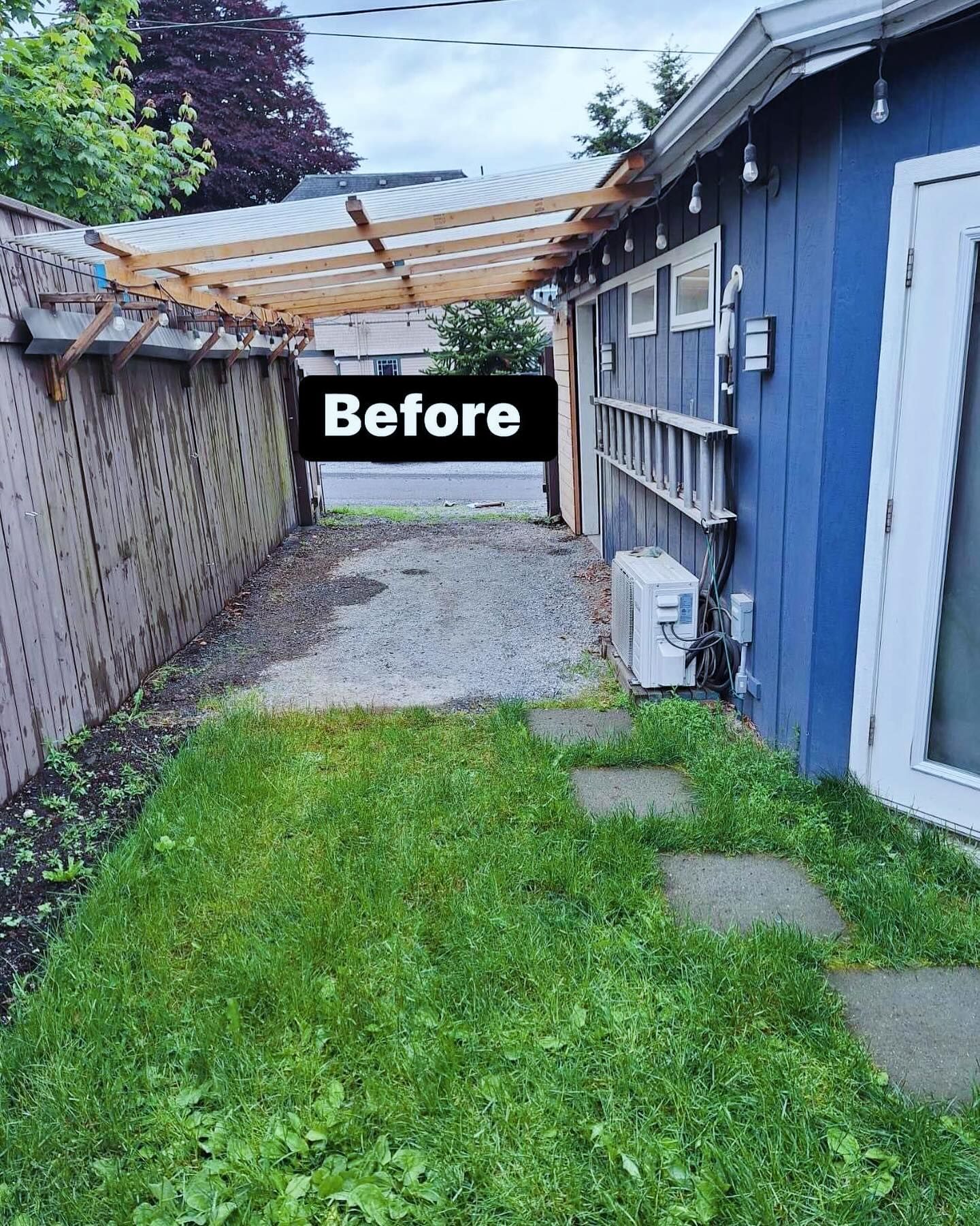 Backyard with blue building, wood fence, pergola, stepping stones, and gravel pathway.
