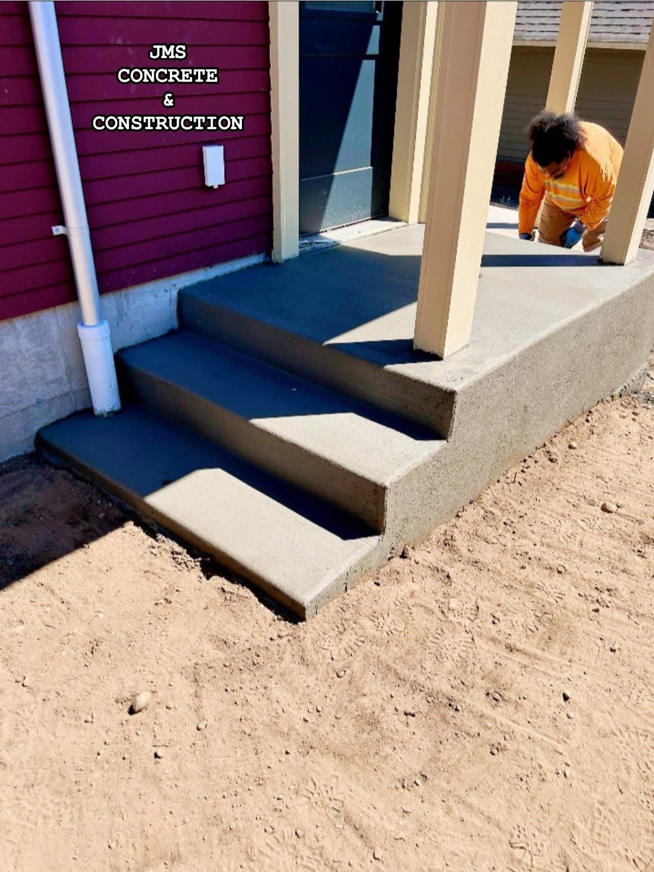 Newly poured concrete steps leading to a porch with a child playing.