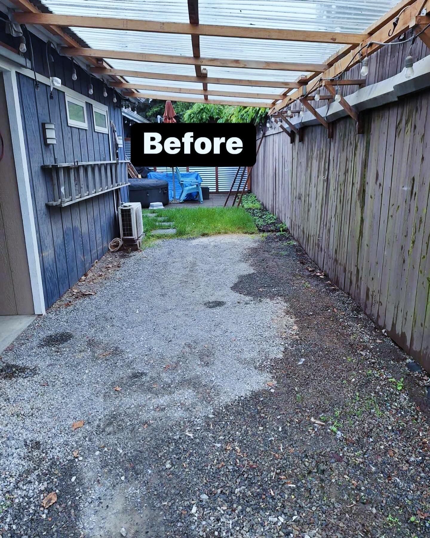 Gravel path between two walls, under a covered structure, leading to a small yard.