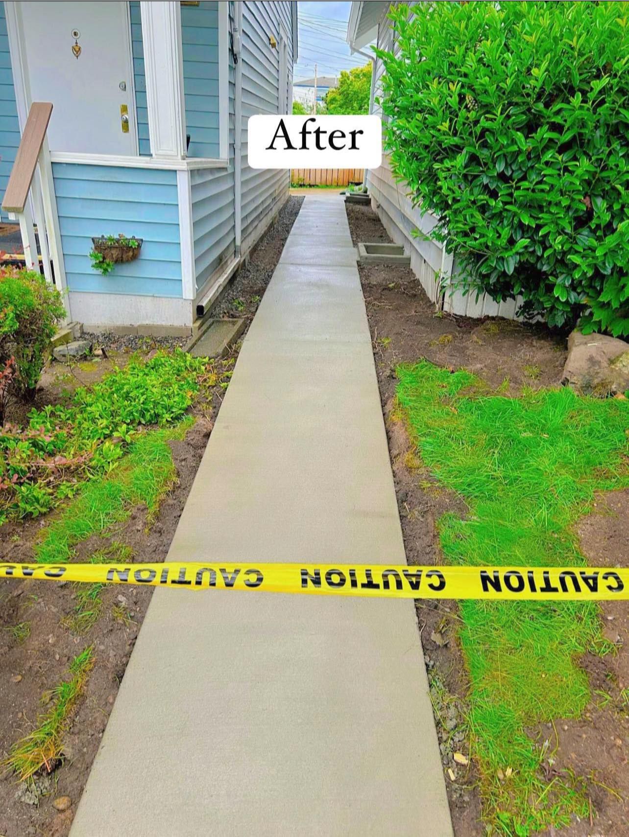 Freshly poured concrete sidewalk with caution tape, flanked by grass and building.