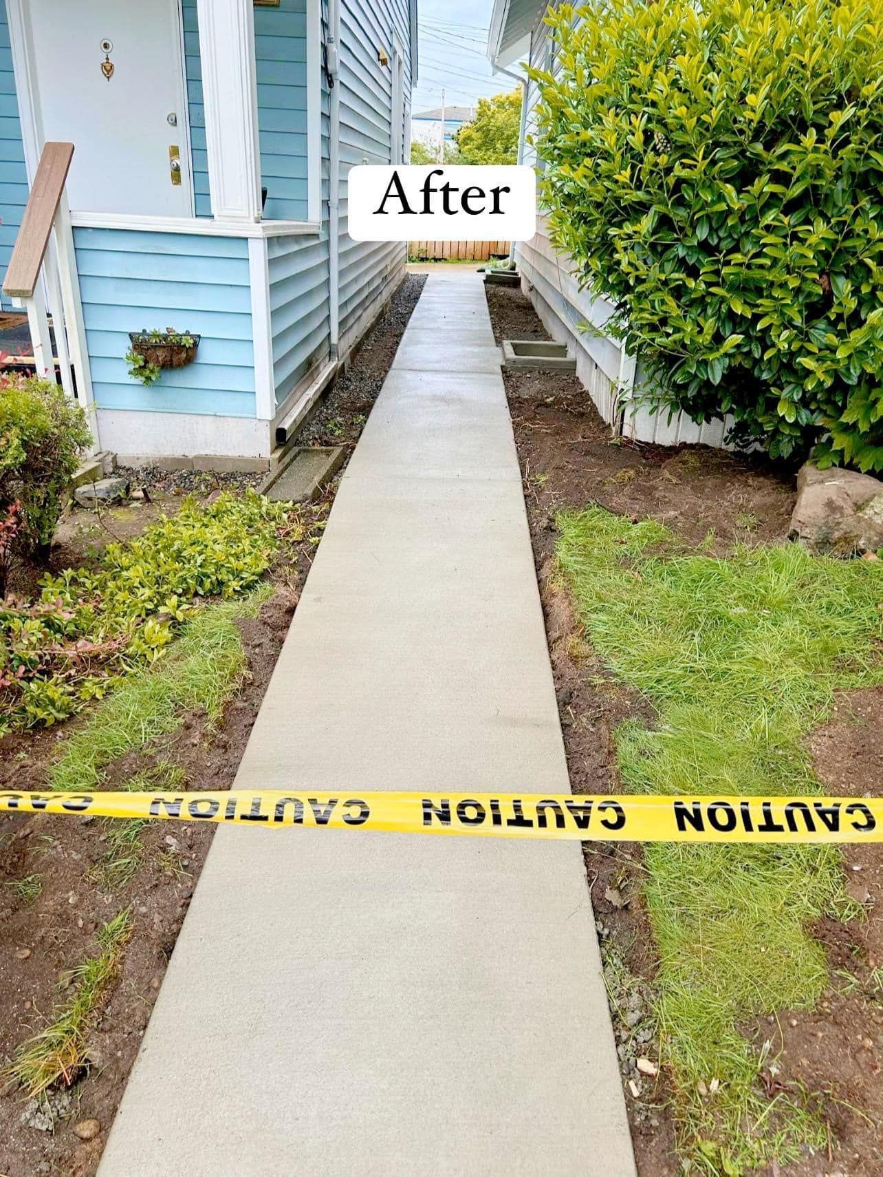 Freshly poured concrete walkway after construction, with caution tape and small plants on each side.