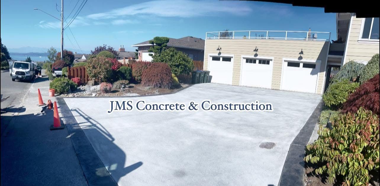 Concrete driveway with a three-car garage and JMS Concrete & Construction text.