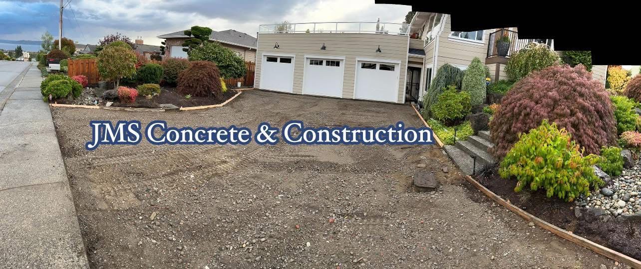 Driveway in front of a house, gravel driveway with landscaped yard and garage.