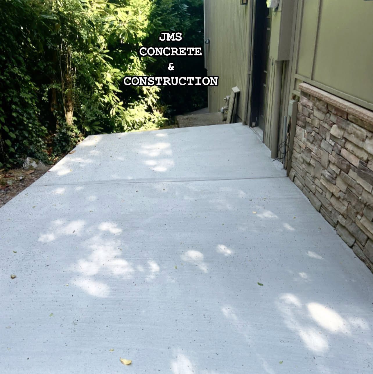 Concrete patio with JMS Concrete & Construction text.