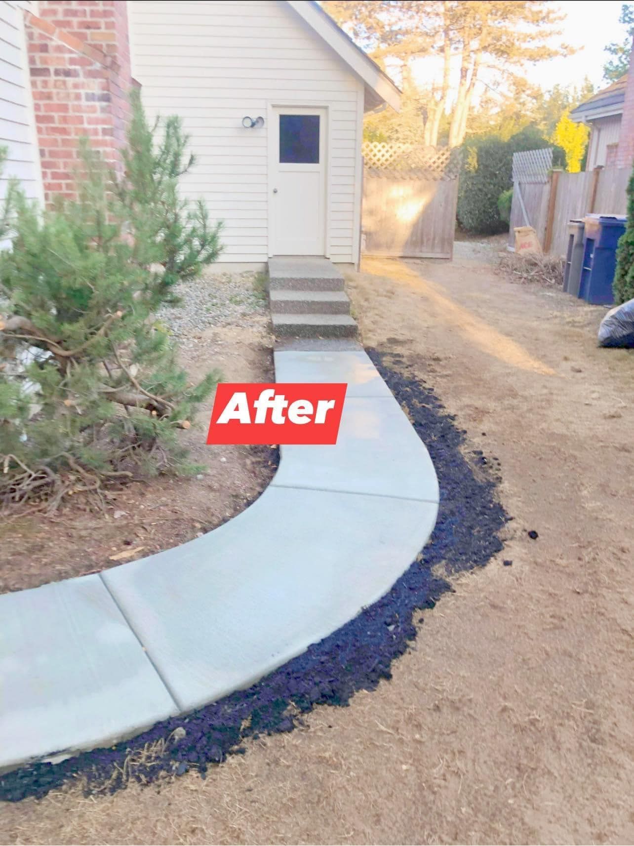 Newly poured concrete sidewalk curves up to a building entrance.