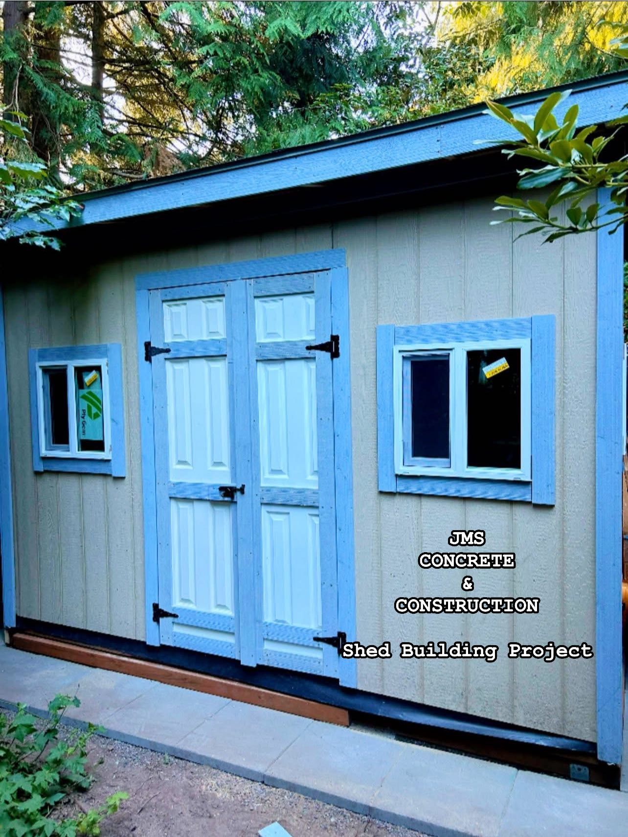 Light blue shed with white double doors, two windows, and dark trim.