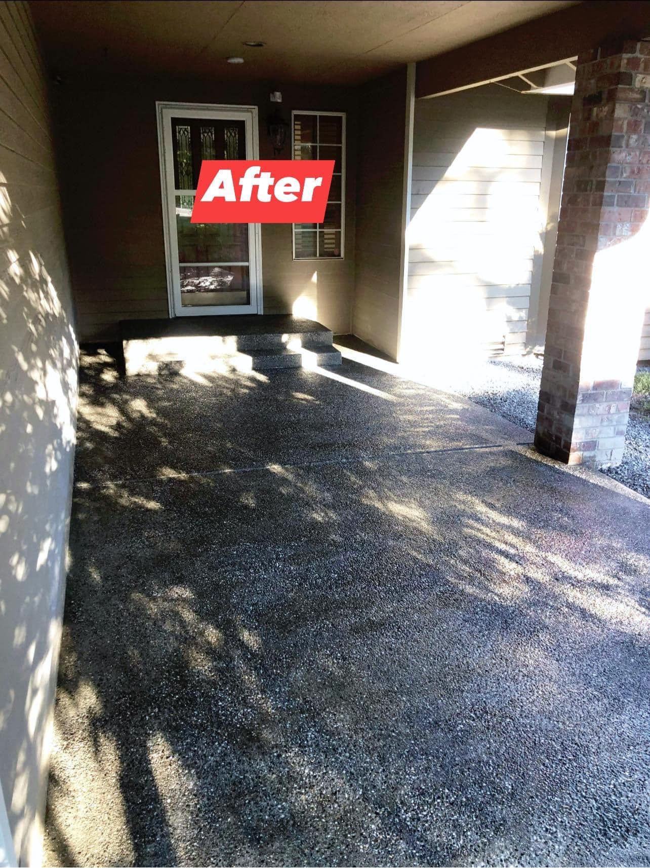 Covered porch with dark aggregate flooring and gray walls; door with