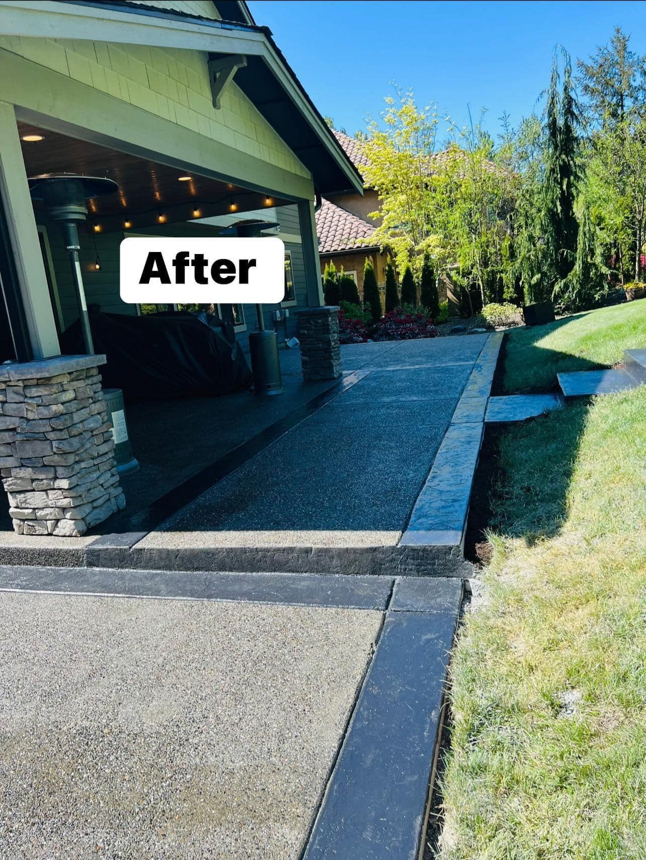 Concrete patio with black border, next to lawn and covered outdoor seating area, sunny day.