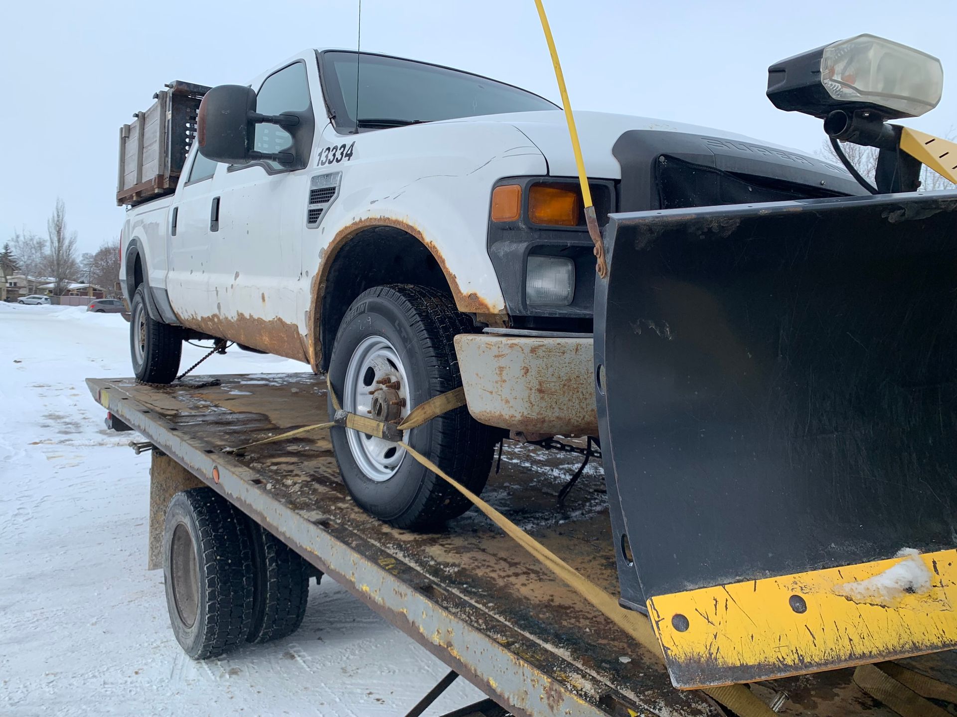 towing snow plow truck on flatbed