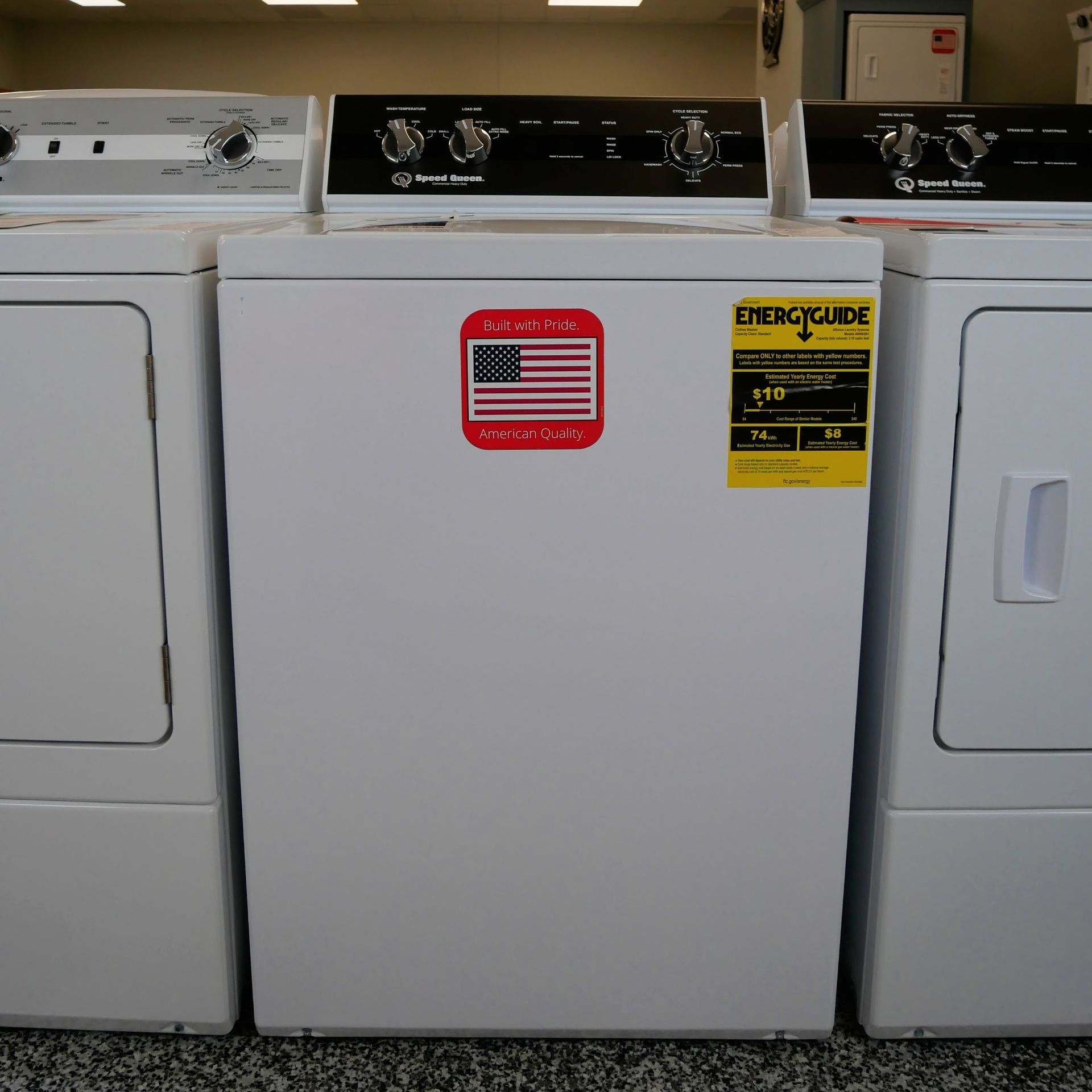 Three white washing machines and dryers side by side in a store.