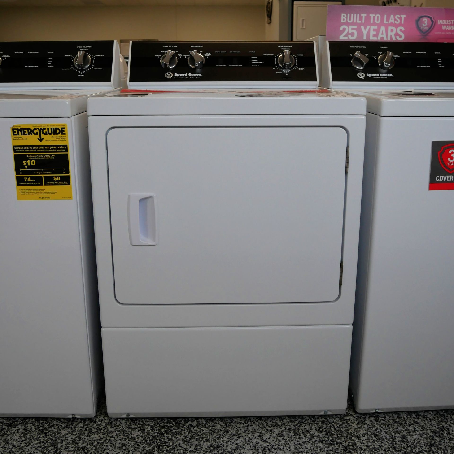 Three white electric clothes dryers with control panels and doors.