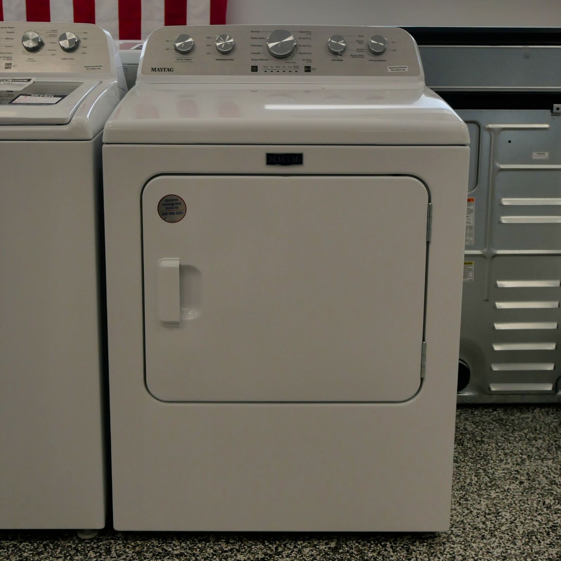White Maytag clothes dryer with top controls, front door and handle.