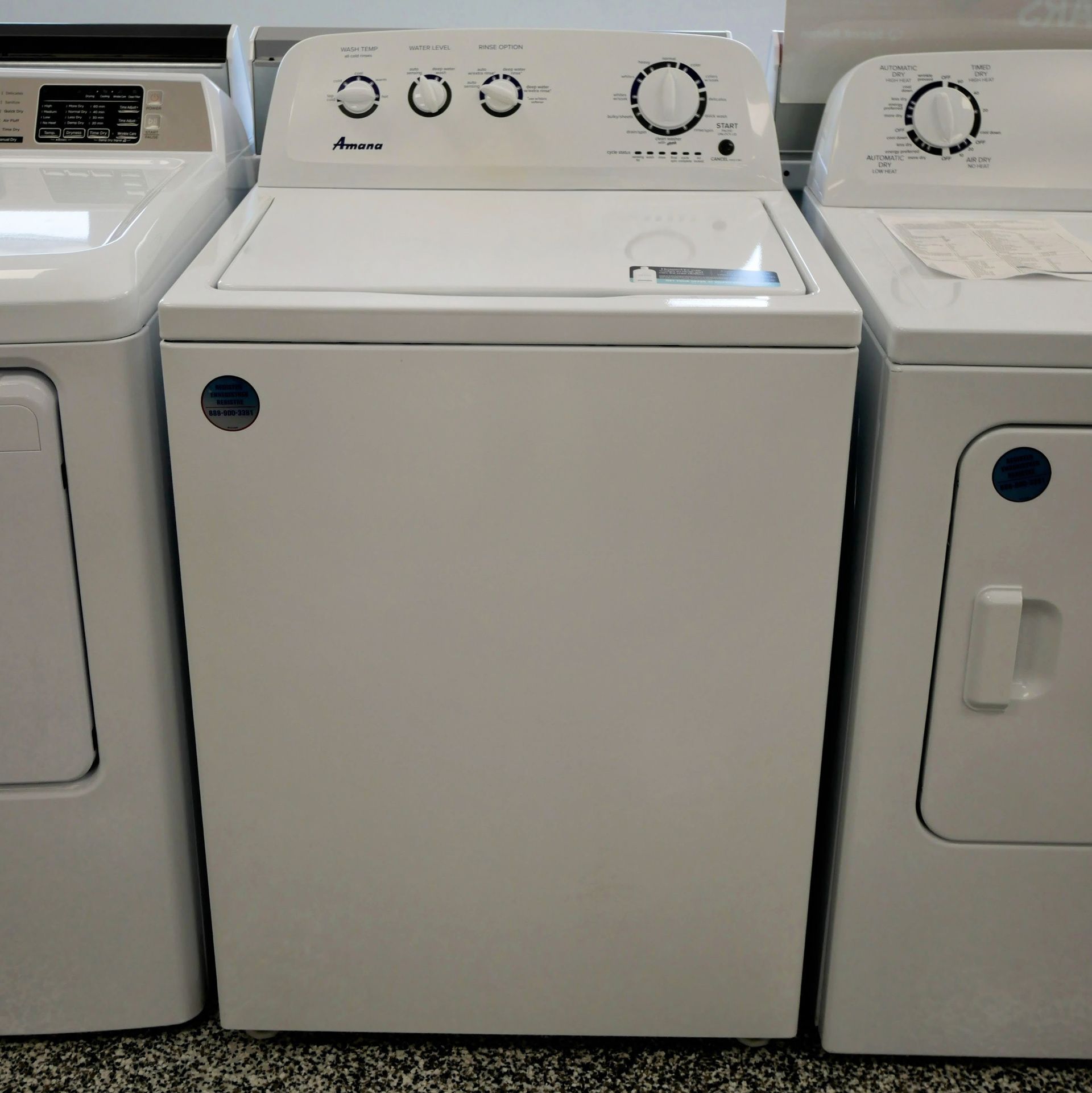 White top-load washing machine with control knobs and a matching dryer on either side.