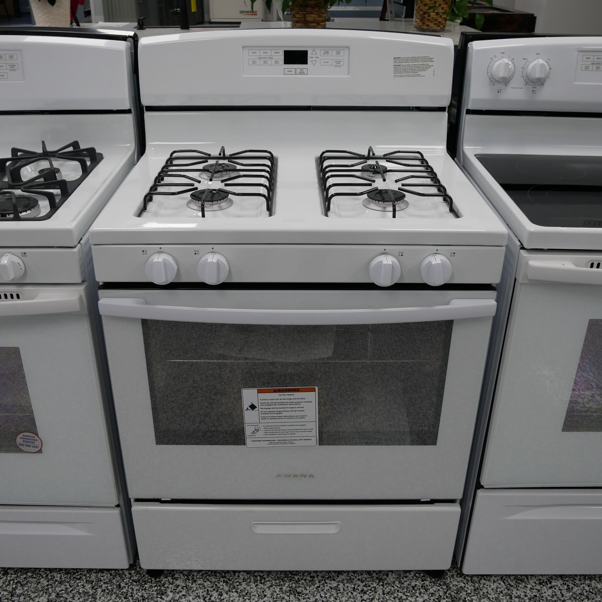 White gas range with four burners, oven, and storage drawer.