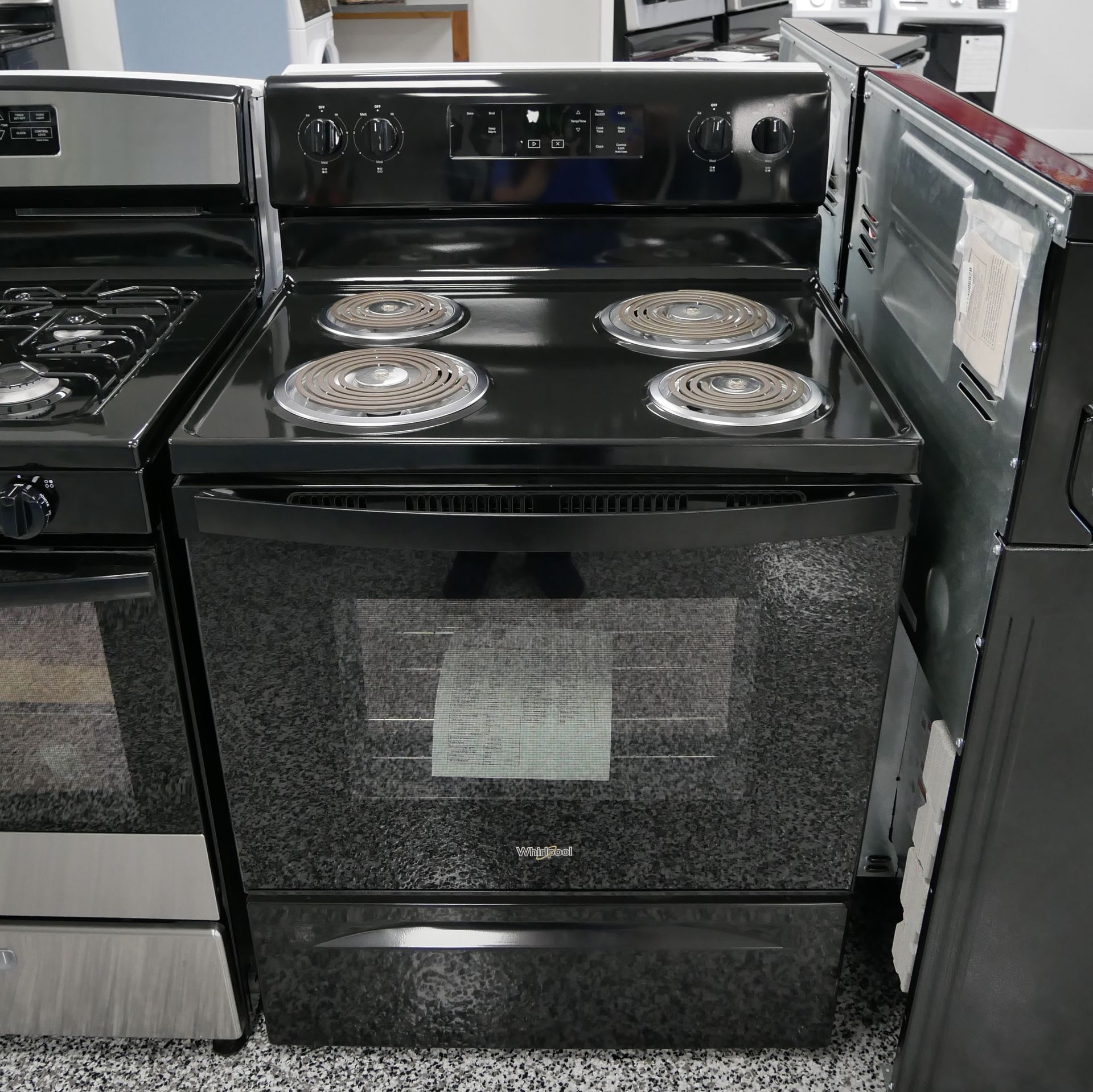 Black electric range with four burners, oven, and control panel.