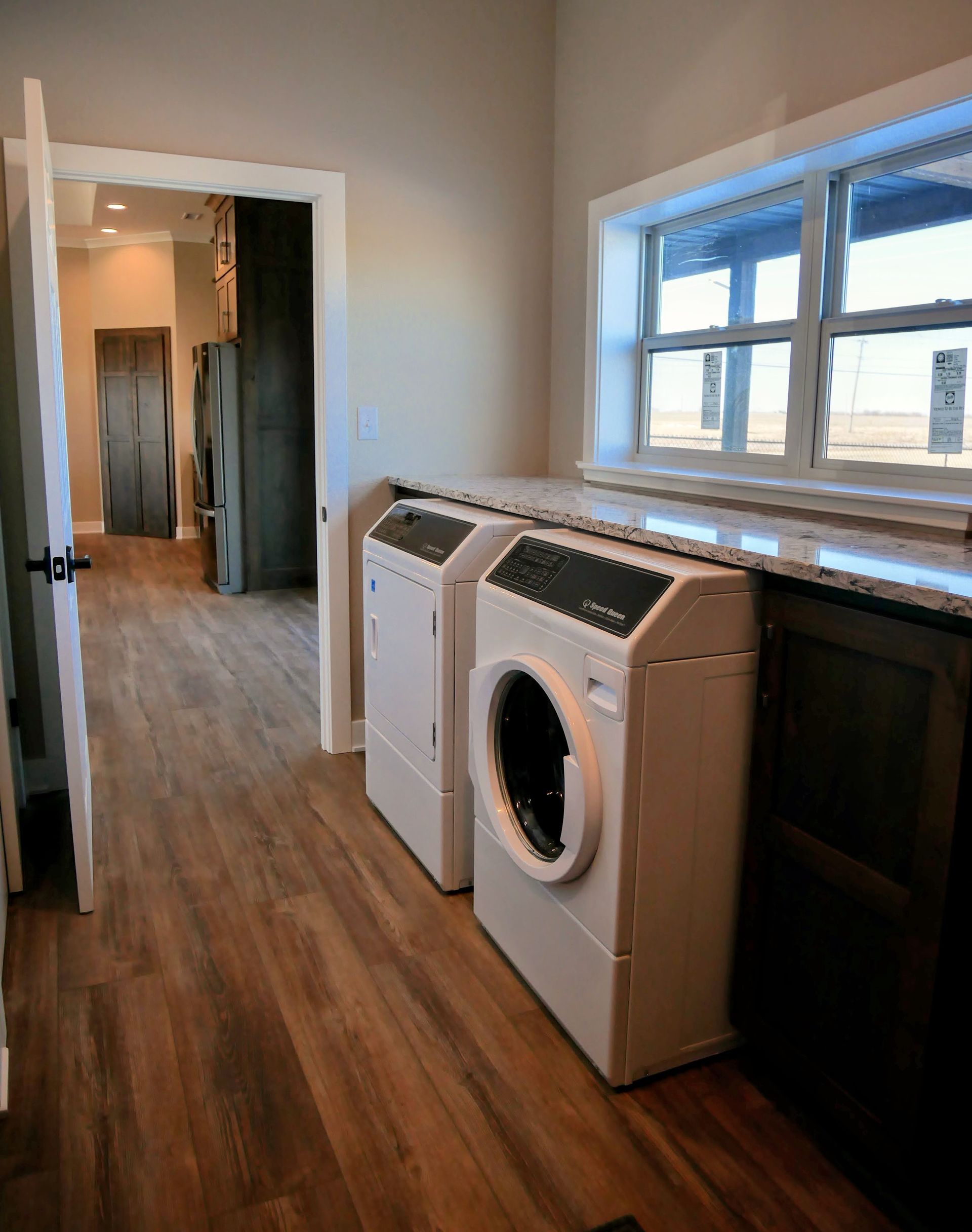A laundry room with a washer and dryer and a window