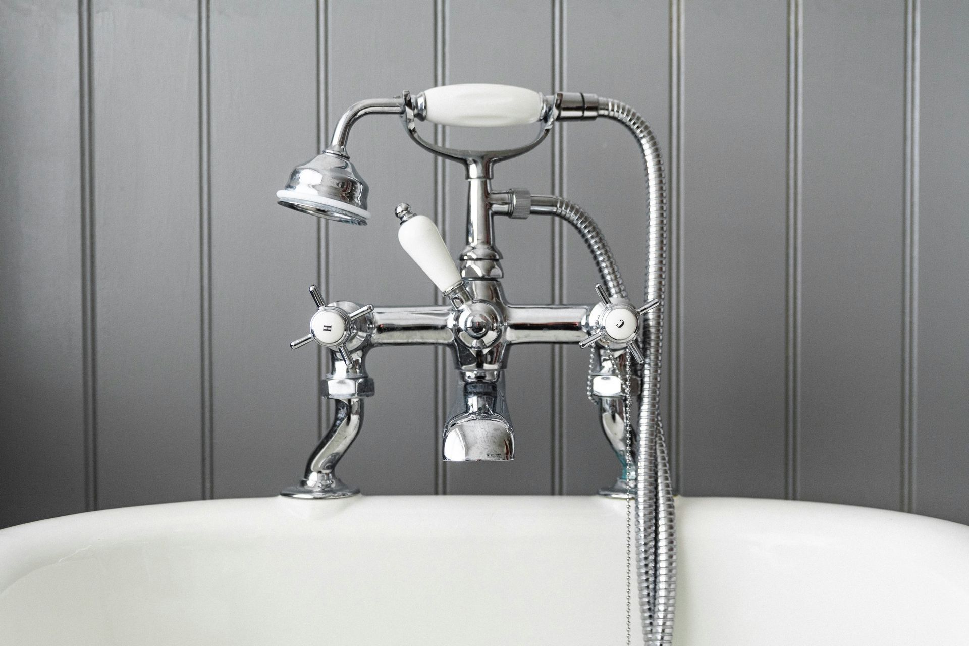 A bathtub with a chrome faucet and shower head.