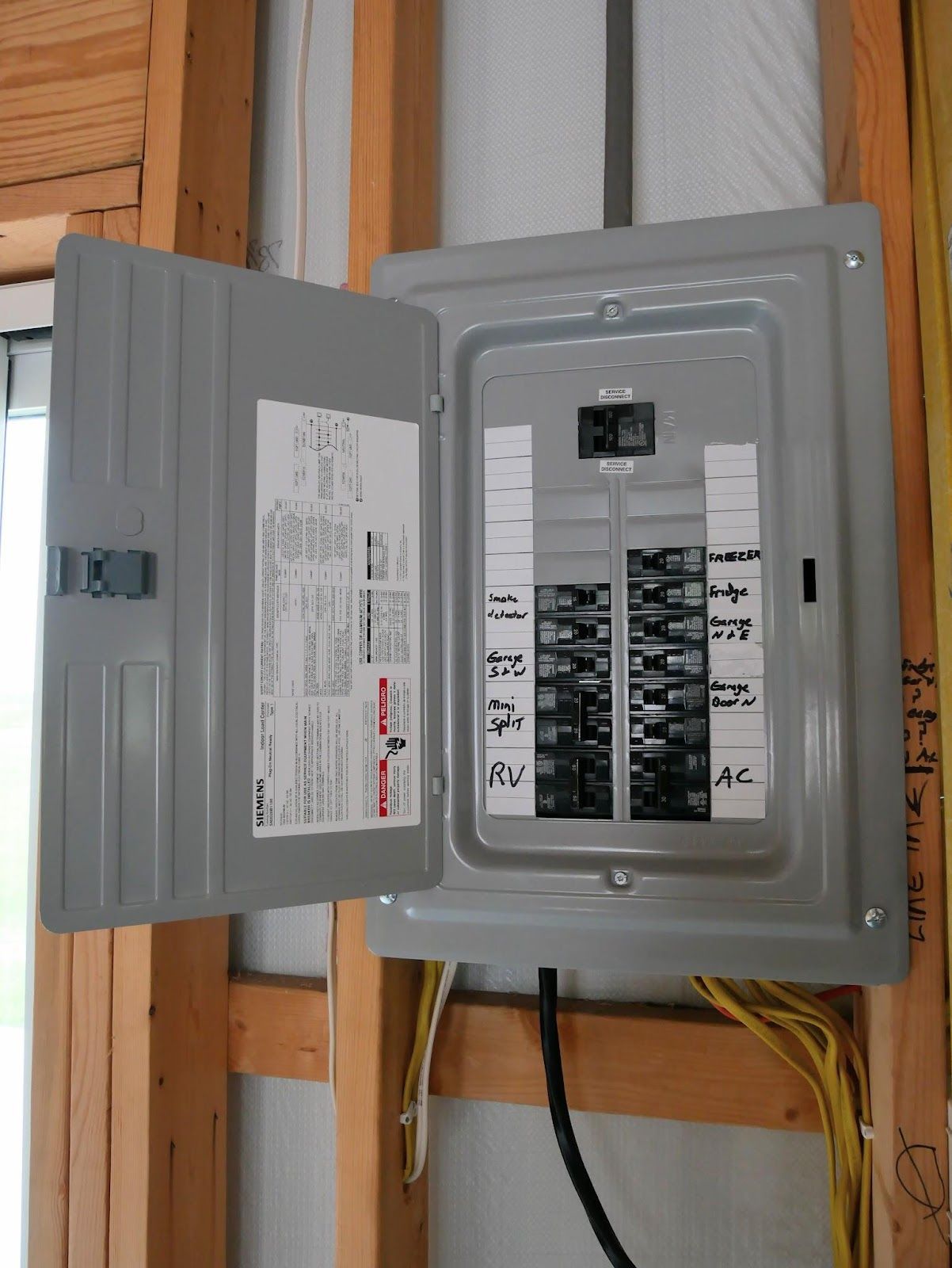 A electrical box with the door open and labels on it