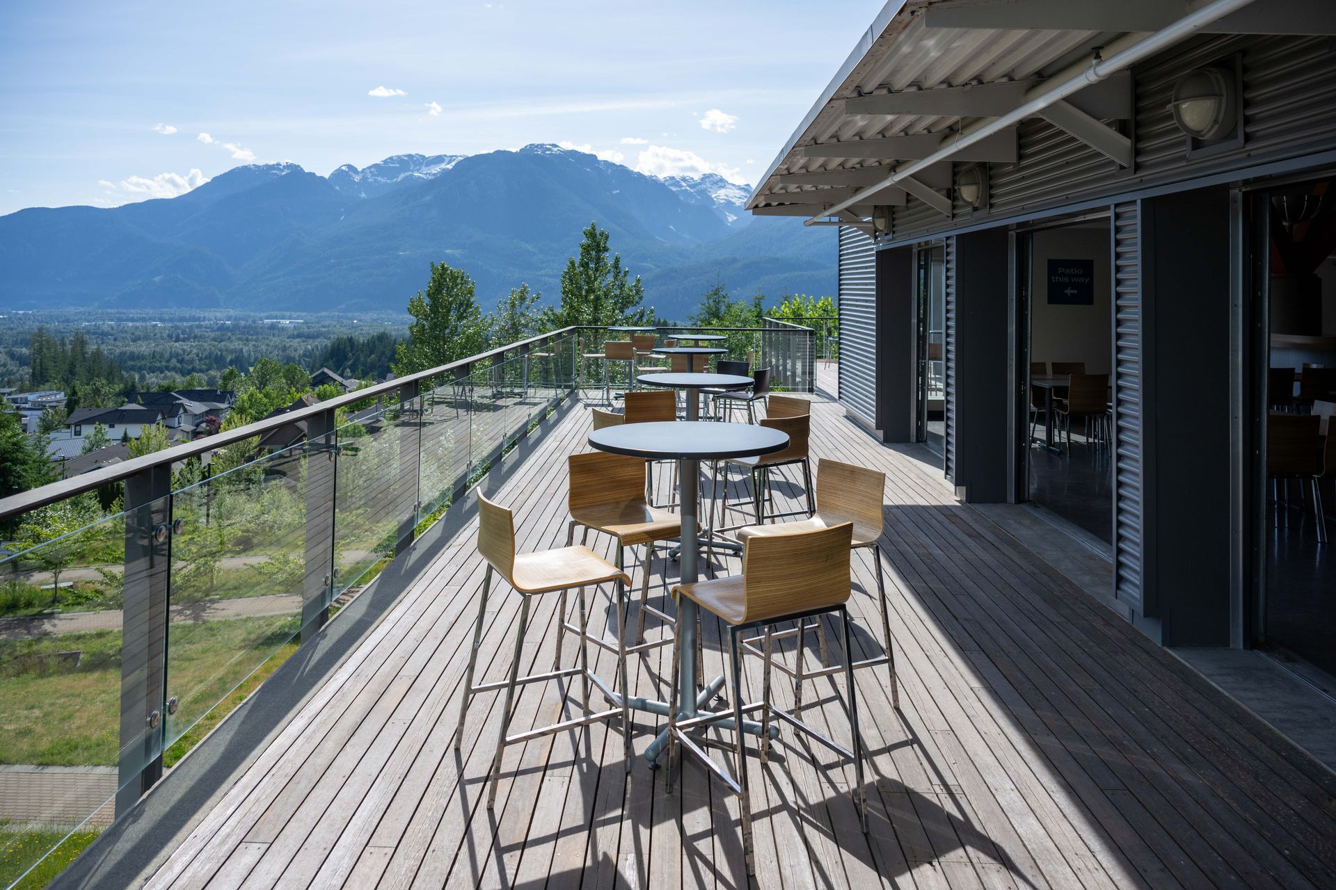 Mountain-view patio with table and chairs beside a modern building