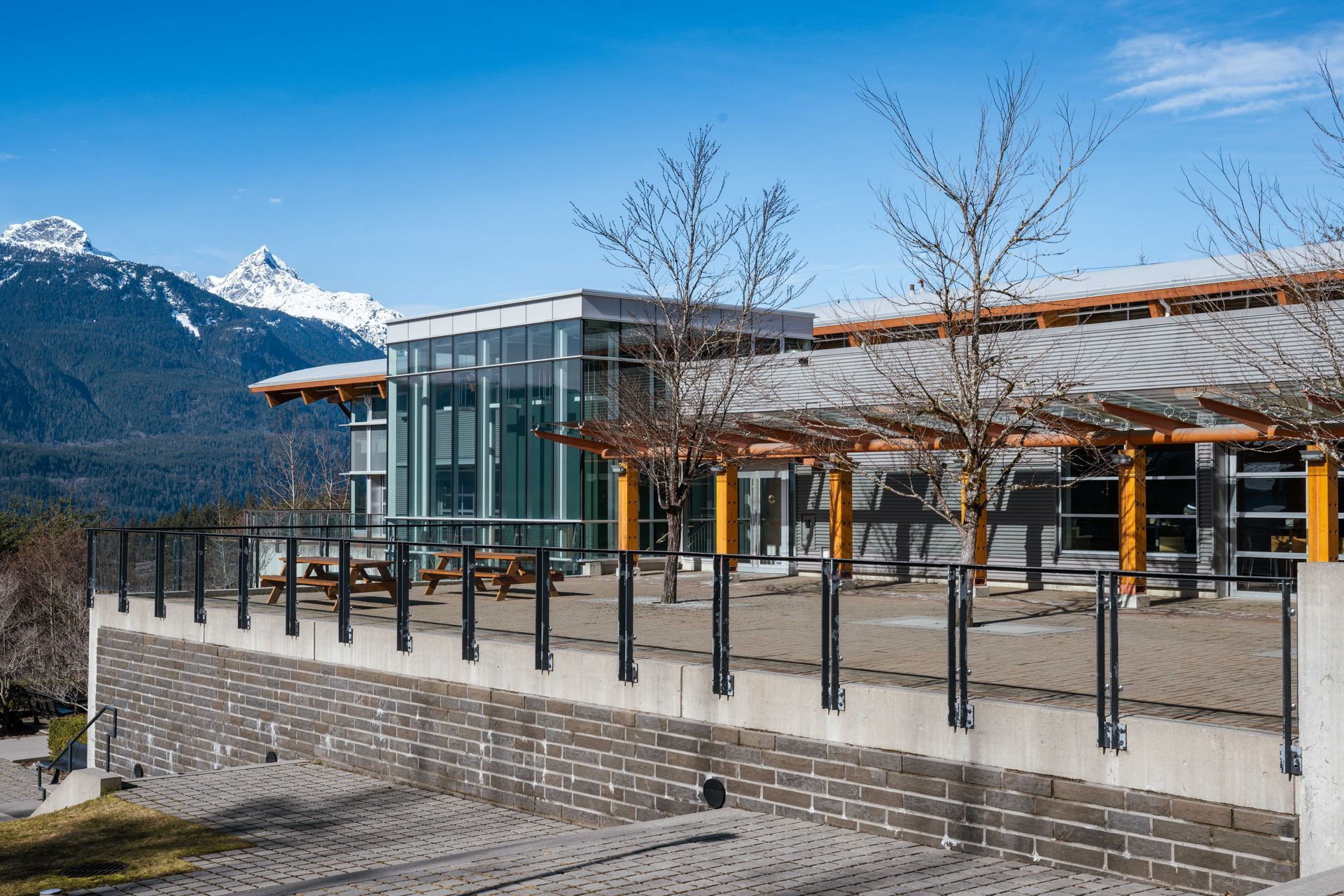 Building with patio and mountain view under blue sky.