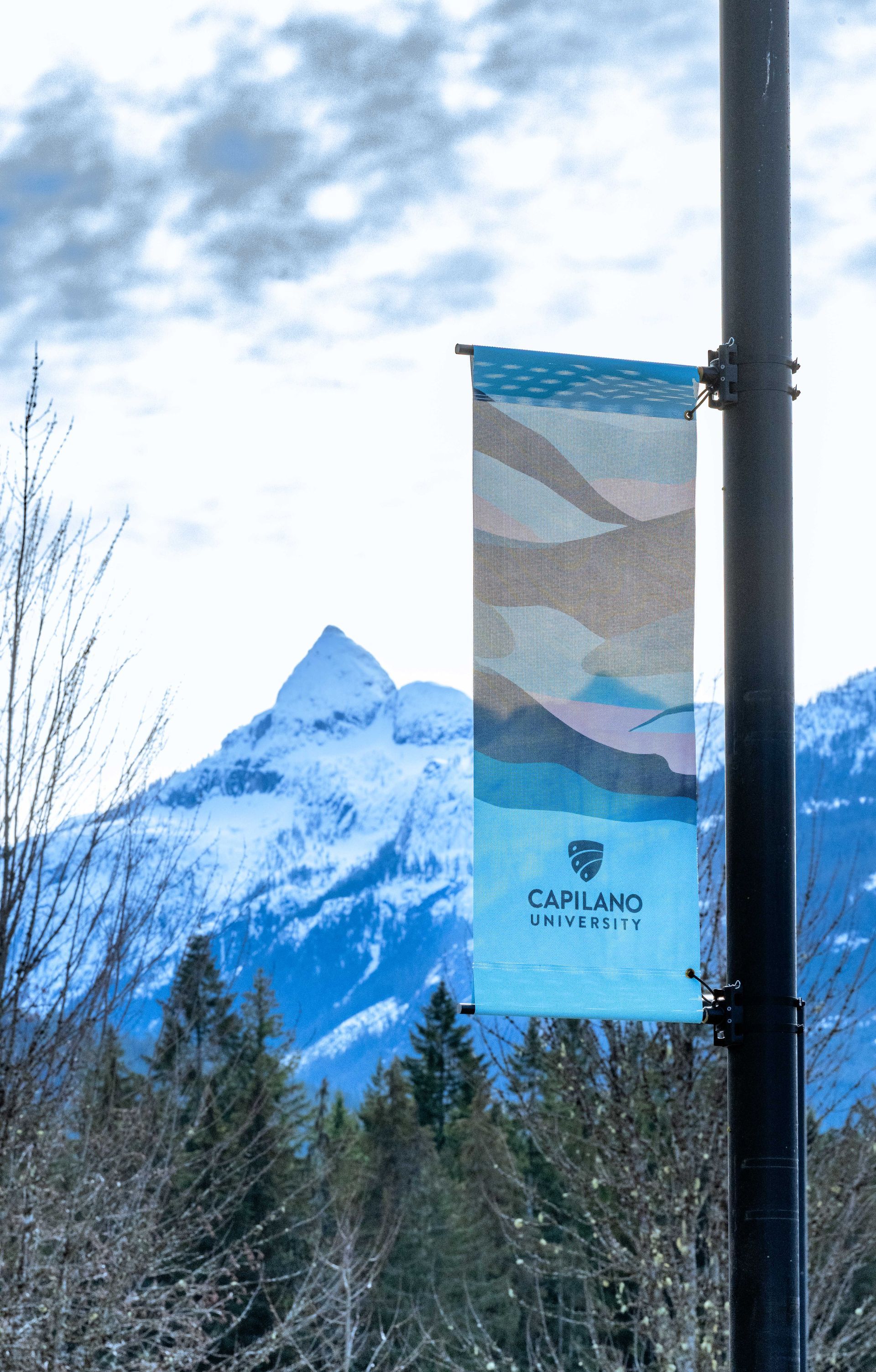 Banner on a pole with a mountain backdrop; the banner reads 