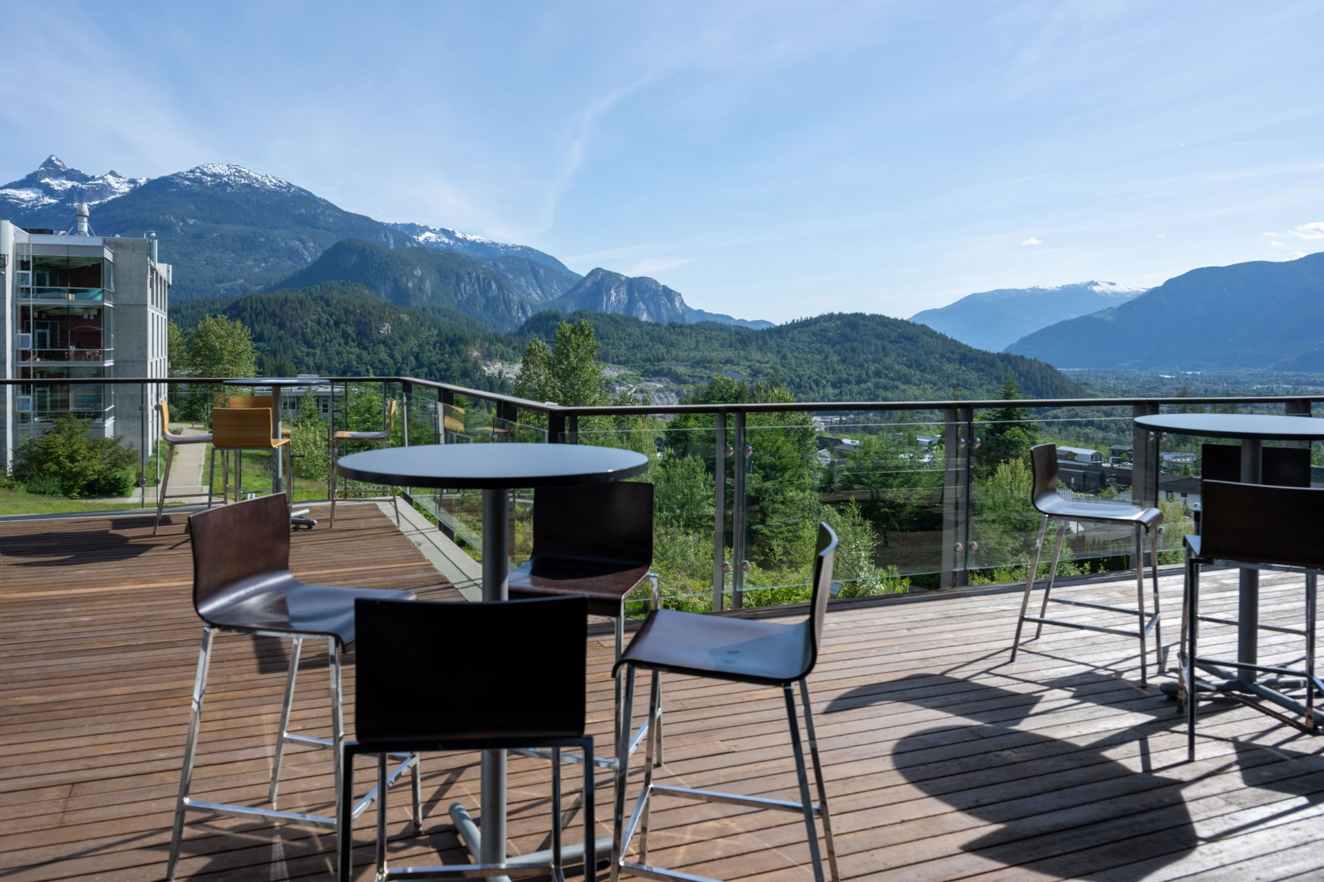 Outdoor terrace with tables and chairs overlooking a mountain landscape