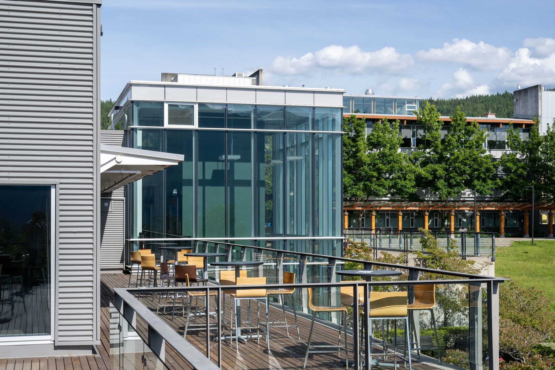 Modern glass patio and terrace overlooking a landscaped courtyard under a sunny sky