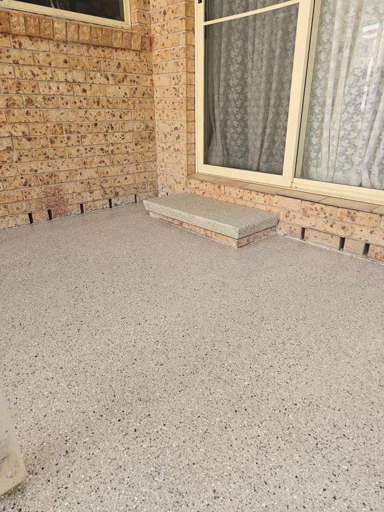 A Brick Wall With a Window and a Concrete Floor in Front of It — Mid North Coast Spray Pave in South West Rocks, NSW
