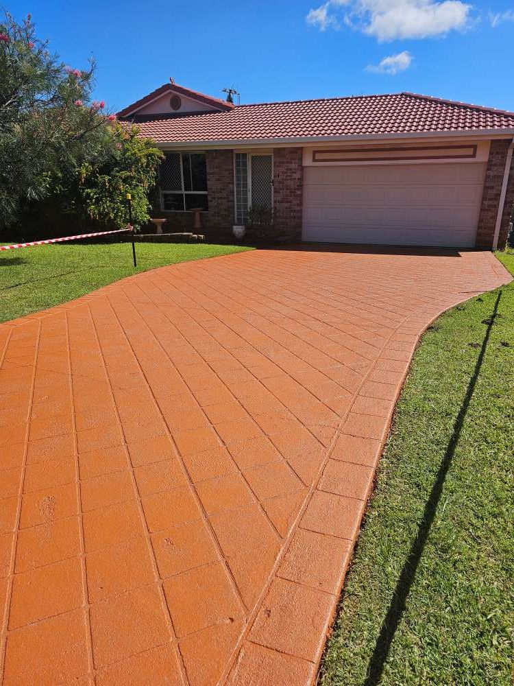 A Driveway Leading to a House With a White Garage Door — Mid North Coast Spray Pave in South West Rocks, NSW