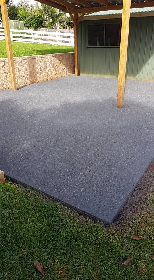 Fresh Gray Concrete Patio Under a Wooden Pergola Beside a Grassy Yard — Mid North Coast Spray Pave in Kempsey, NSW