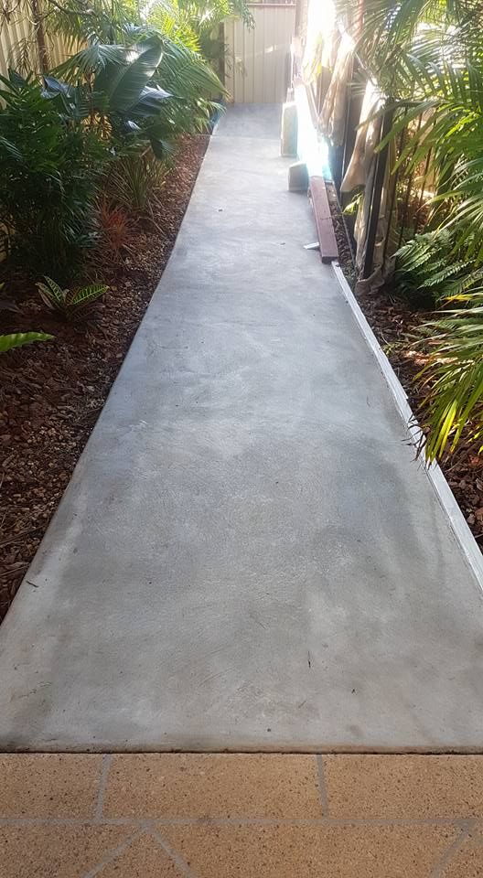 A Concrete Walkway Leading to a House Surrounded by Trees and Bushes — Mid North Coast Spray Pave in Port Macquarie, NSW