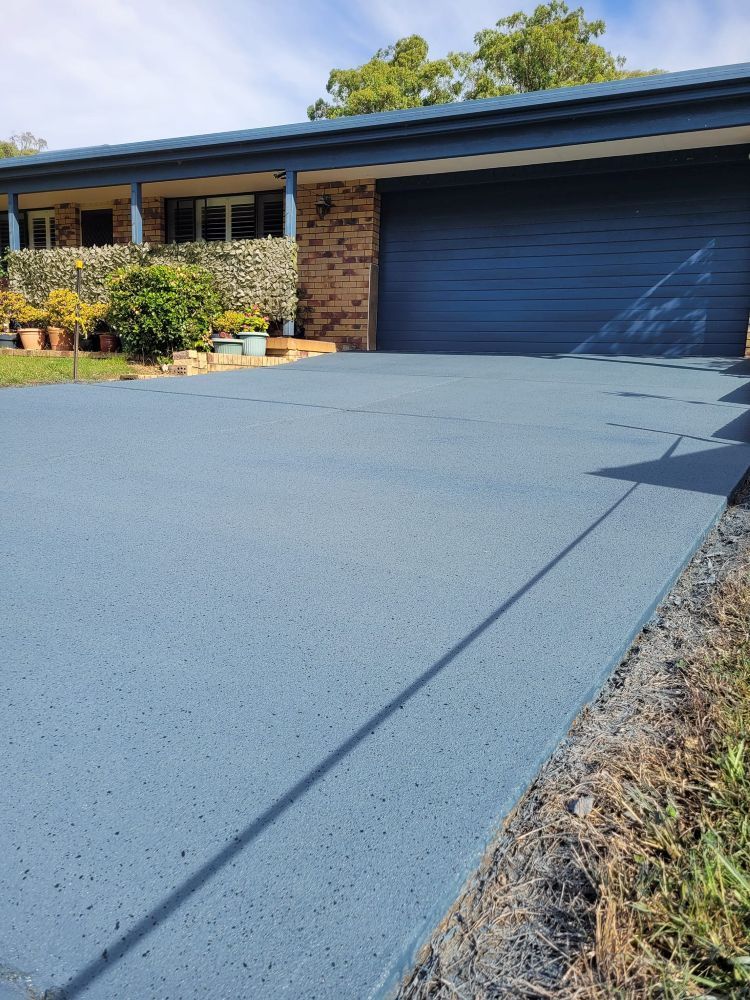 A Driveway Leading to a House With a Blue Garage Door — Mid North Coast Spray Pave in Port Macquarie, NSW