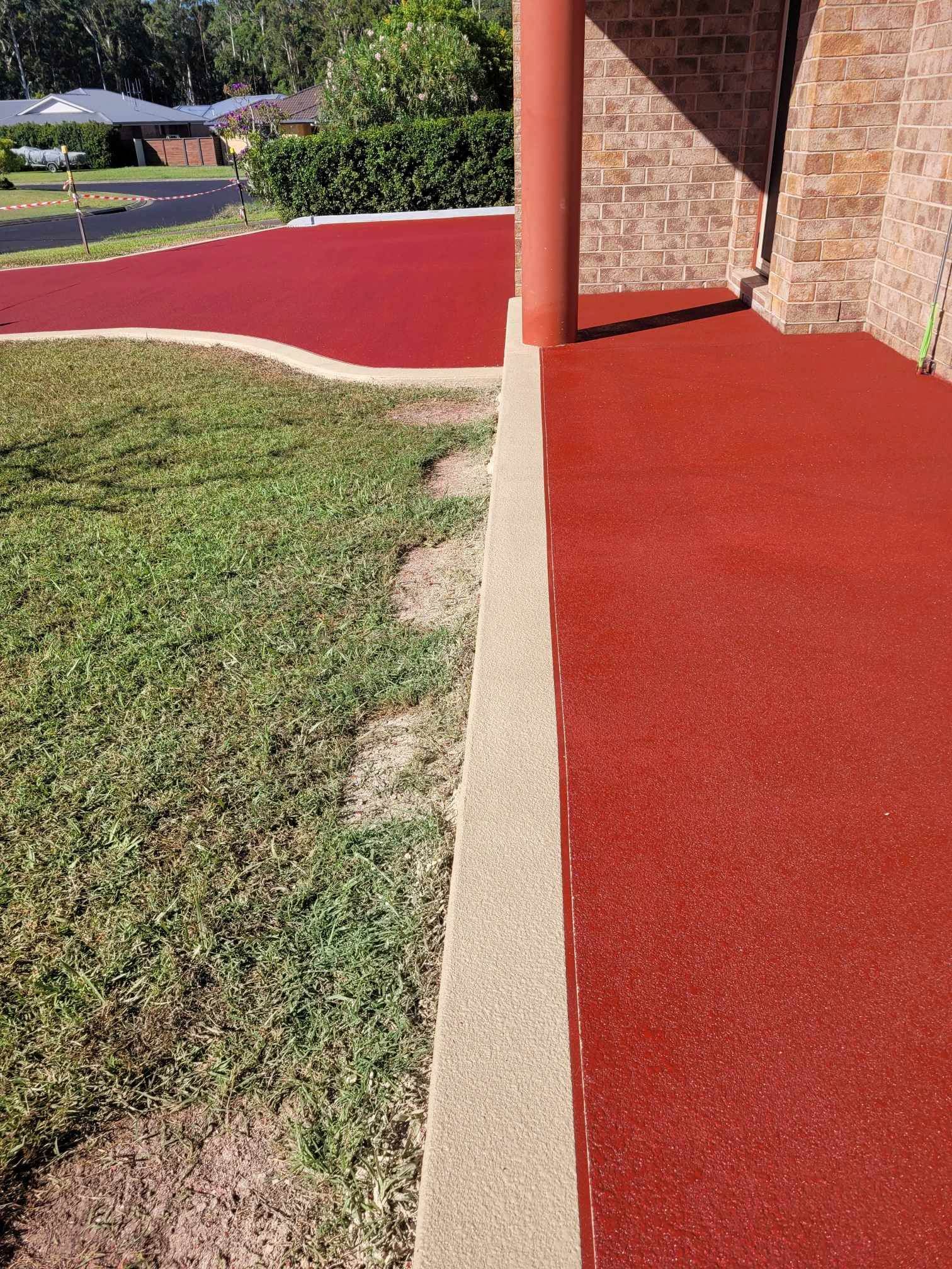 A Red Walkway Leading to a Brick Building Next to a Grassy Area — Mid North Coast Spray Pave in Port Macquarie, NSW